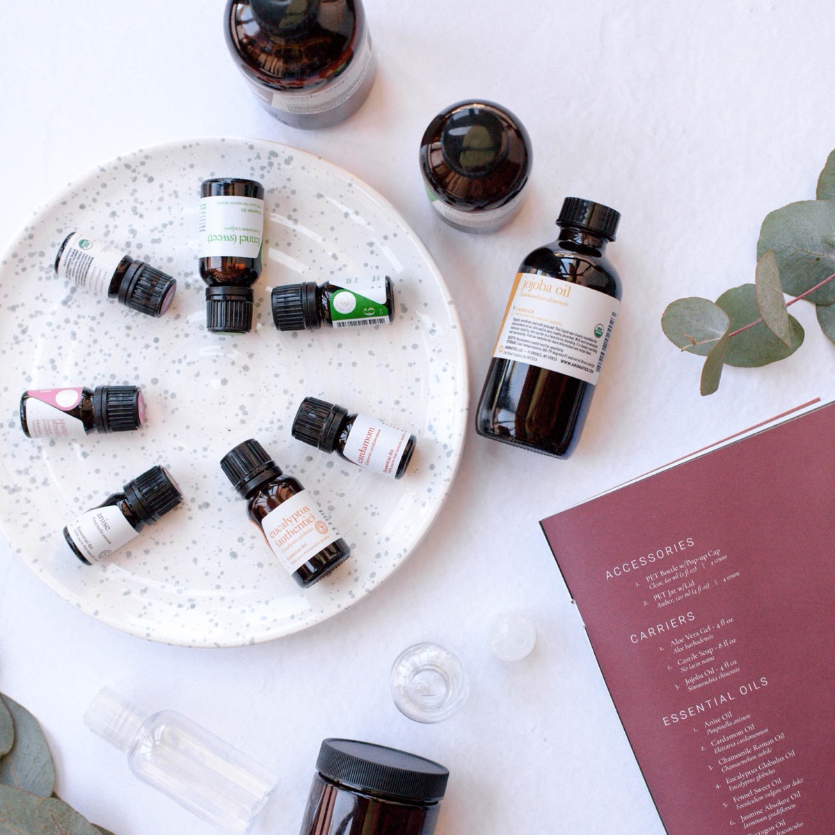 A spread of essential oils, carriers, and a recipe card